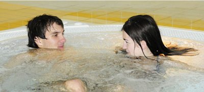 Dwie osoby relaksują się w basenie z hydromasażem w strefie spa