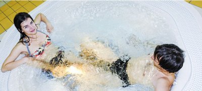 Kobieta i mężczyzna relaksują się w jacuzzi z bąbelkami na basenie