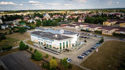 Widok z lotu ptaka na budynek hotelu w mieście z parkingiem i zabudową w tle