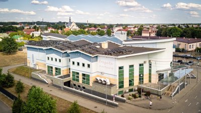 Budynek krytej pływalni Fregata w Kolbuszowej widziany z lotu ptaka na tle miasta
