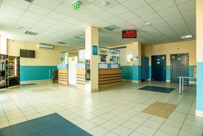 Hol wejściowy pływalni z kasą, bramkami, szafkami, automatami i zegarem elektronicznym