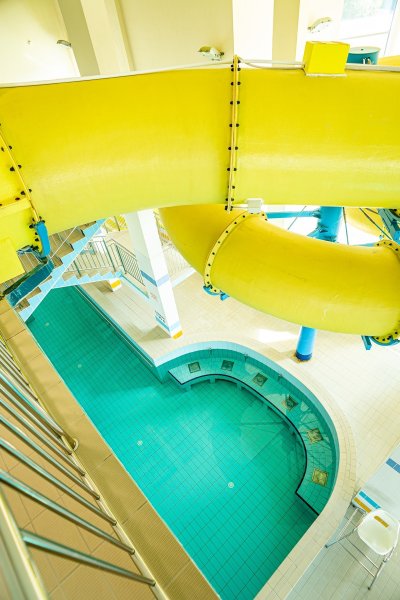 Żółta zjeżdżalnia wodna nad basenem w aquaparku
