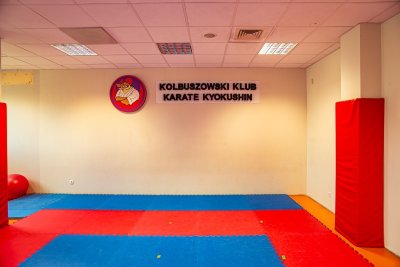 Sala treningowa Kolbuszowskiego Klubu Karate Kyokushin z kolorowymi matami i ochronnymi materacami