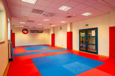 Sala treningowa karate z czerwono-niebieskimi matami i oznaczeniem Kolbuszowskiego Klubu Karate Kyokushin
