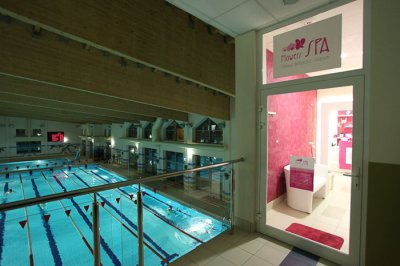Basen pływacki z torami i wejściem do strefy spa za przeszklonymi drzwiami